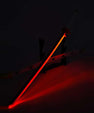 LED katana sword with glowing red blade on display stand in dark setting